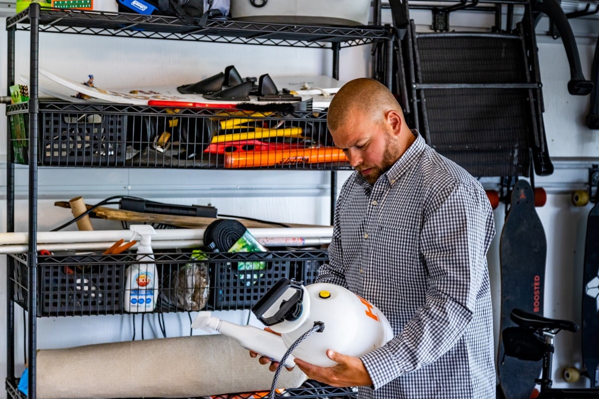 homeowner looks at pest control bottles in garage