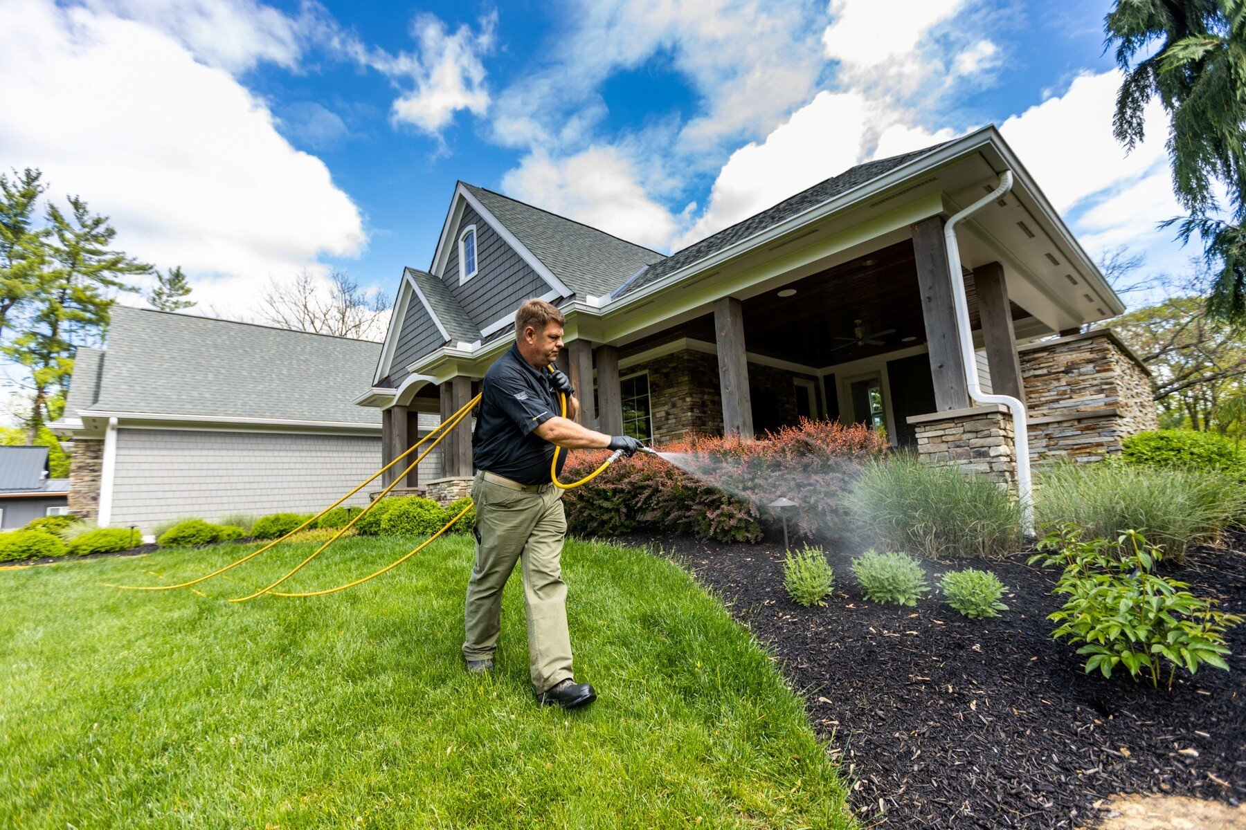 pest control technician spraying for mosquitoes