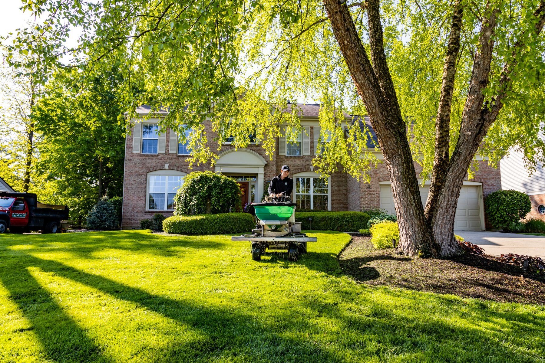 lawn care technician applying granular fertilizer