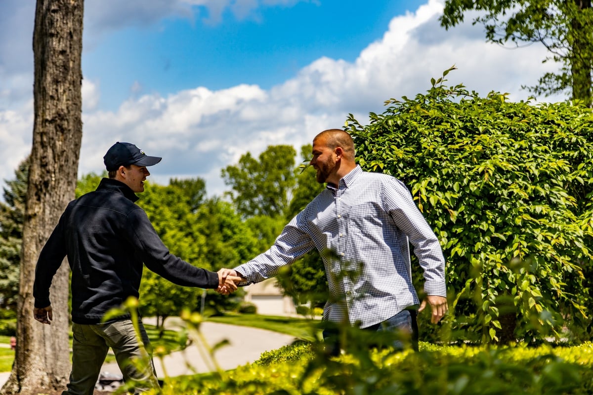 lawn care technician with a customer