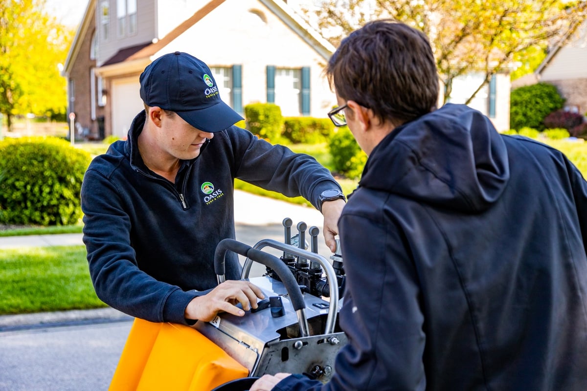 lawn care experts prepare machine to fertilize grass