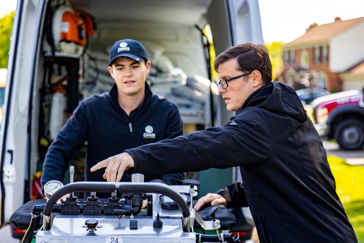 lawn care expert trains new team member on equipment