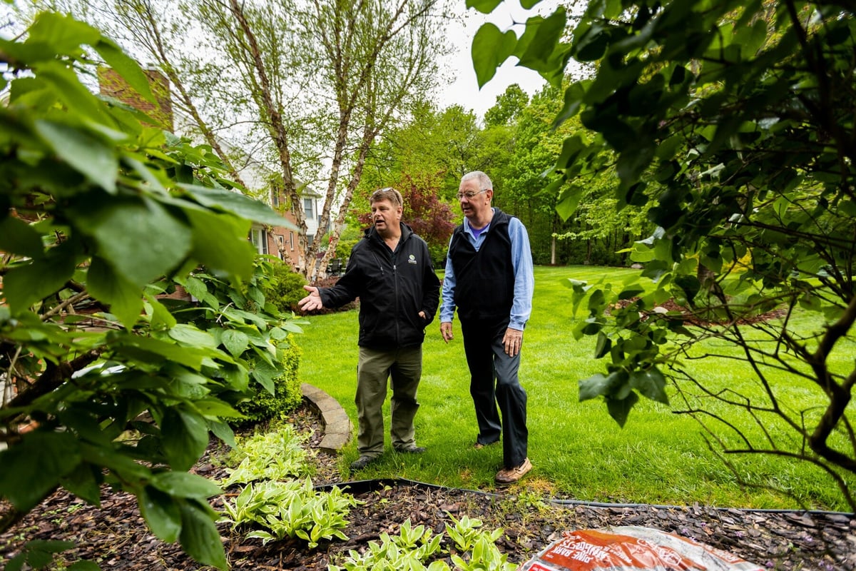 plant health care technician and customer inspect landscape beds