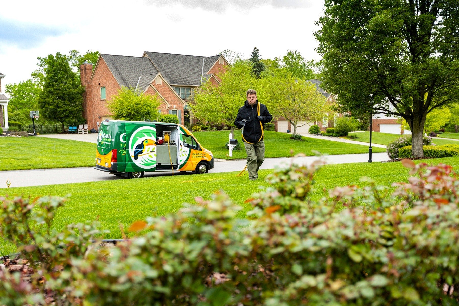 Lawn care company van and technician in Ohio yard