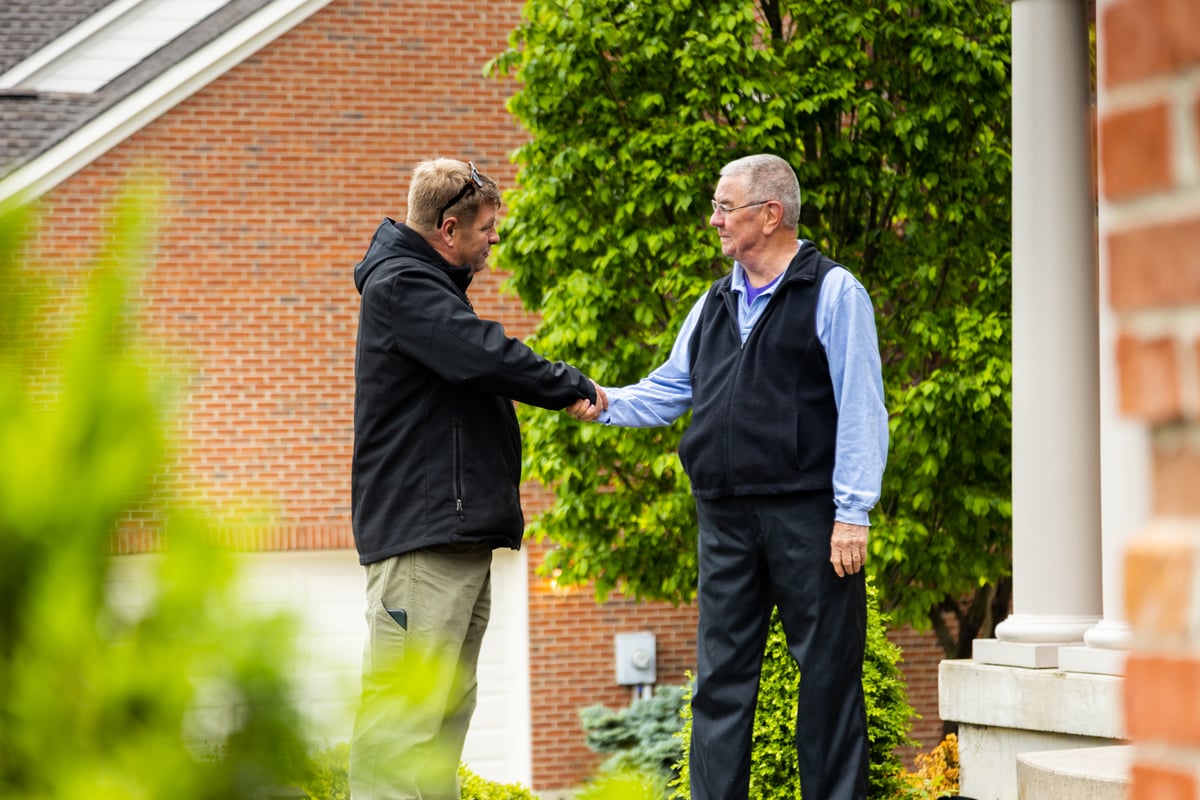homeowner and lawn care expert shake hands