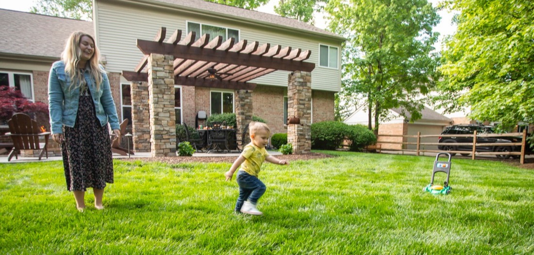 woman and child play in healthy lawn