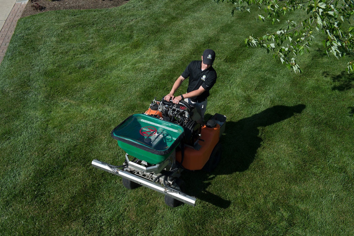 lawn technician spraying to kill weeds in spring in Ohio