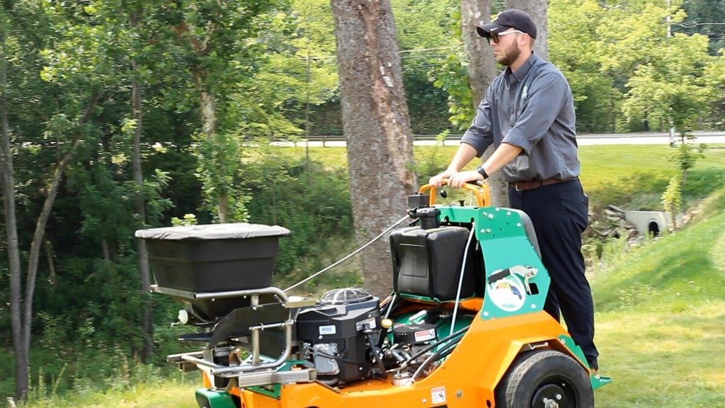 lawn care technician aerating a lawn