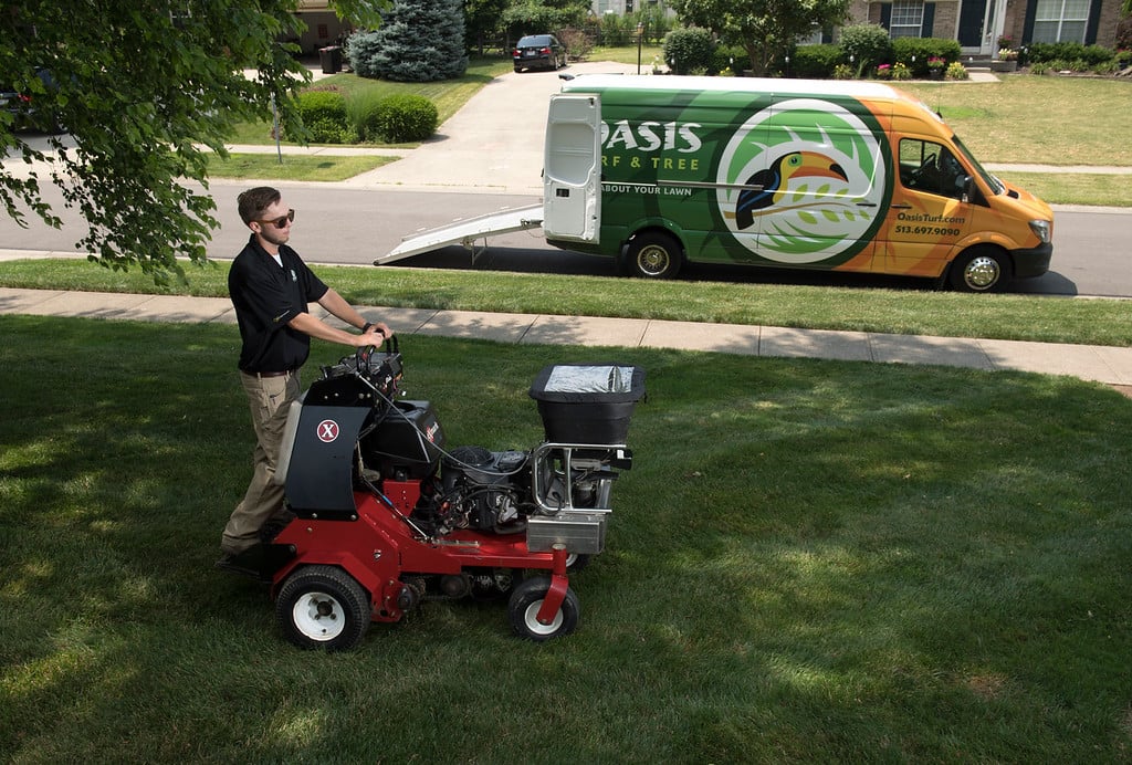 lawn care technician aerates grass