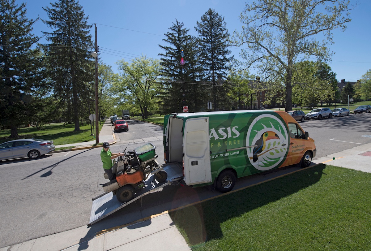 Lawn care technician unloading equipment