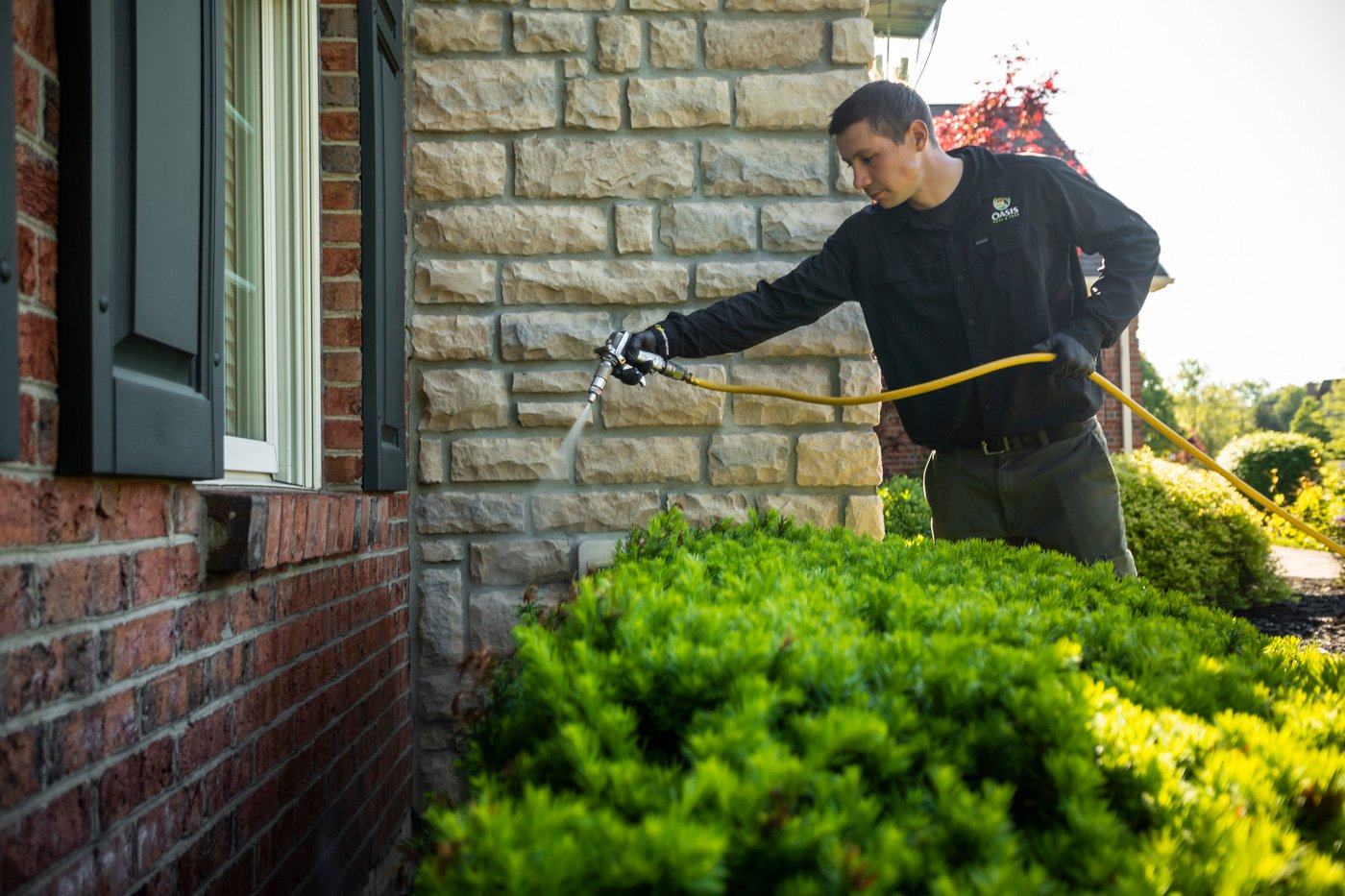 Perimeter pest control technician spraying home in Cincinnati