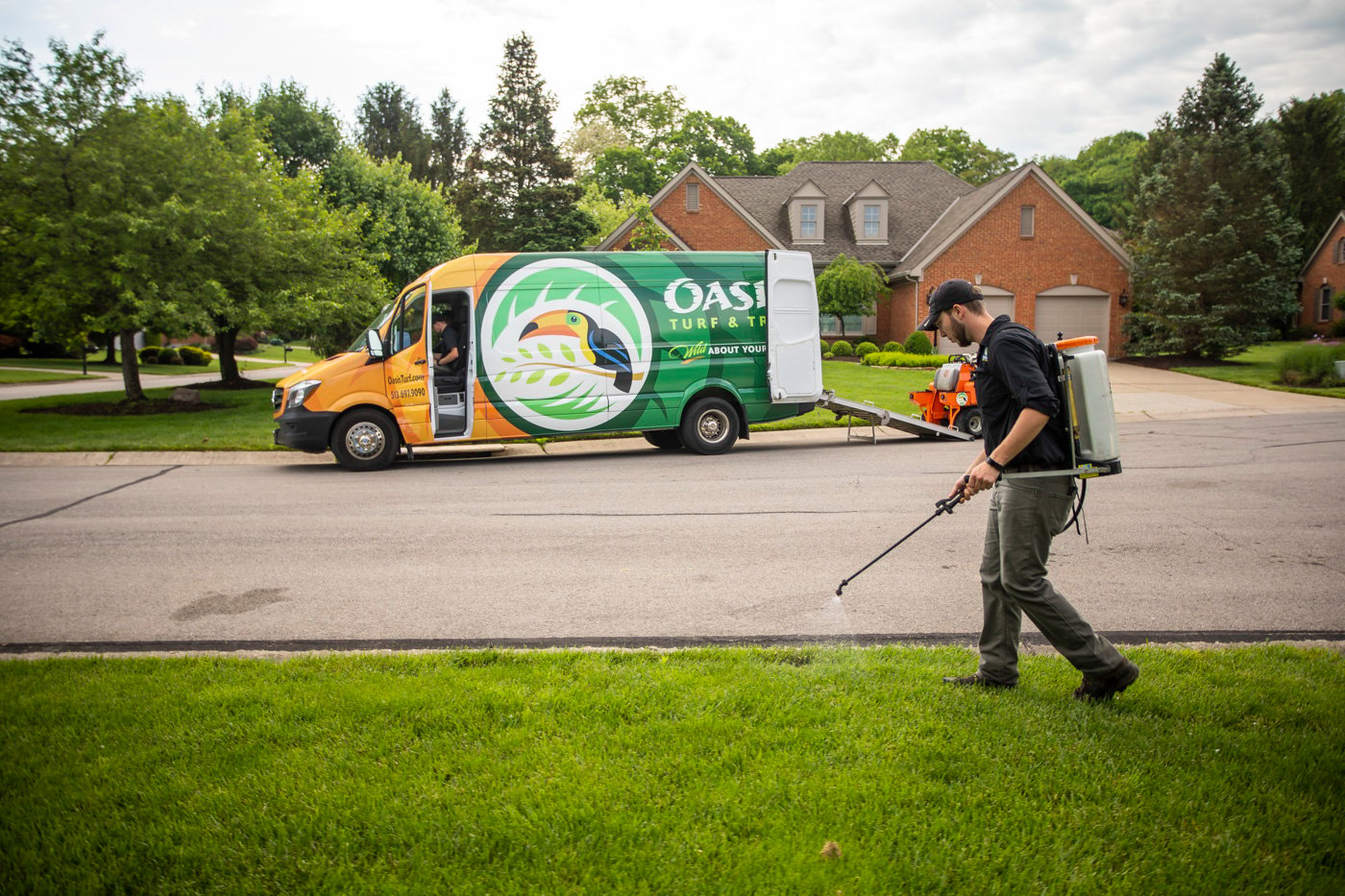Oasis lawn care technician spraying lawn