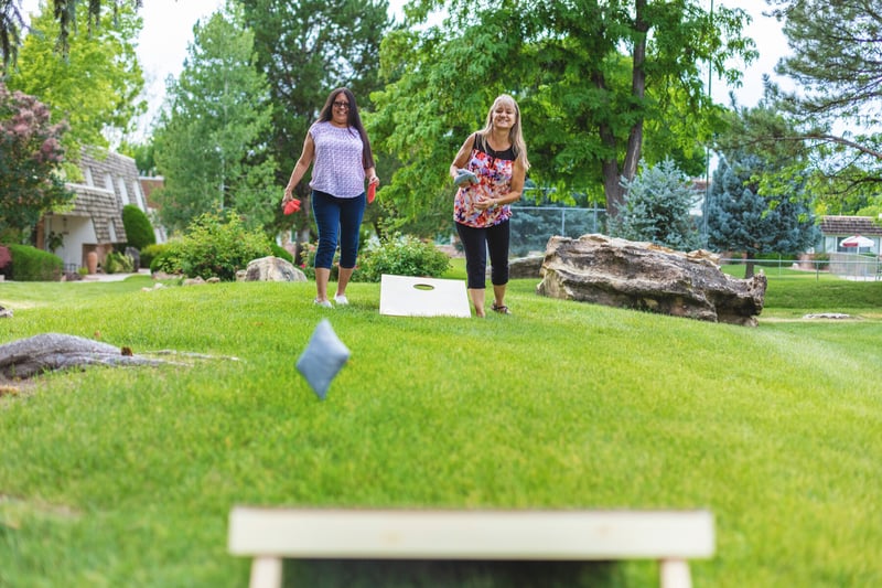 homeowners playing cornhole in the backyard
