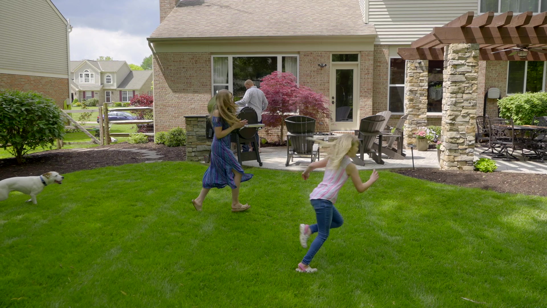 Kids playing in their yard with their dog